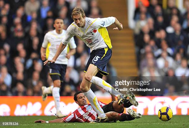 Peter Crouch of Tottenham Hotspur is tackled by Kieran Richardson of Sunderland during the Barclays Premier League match between Tottenham Hotspur...