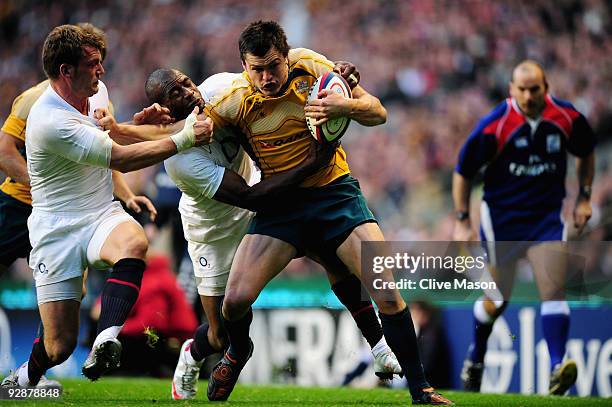 Adam Ashley-Cooper of Australia barges through the attempted tackles from Mark Cueto and Ugo Monye of England to score a try during the Investec...