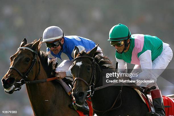 Jockey John Velazquez rides Visit next to Kent Desormeaux atop Dynaforce in the Breeders' Cup Juvenile Filly and Mare Turf race during the Breeders'...