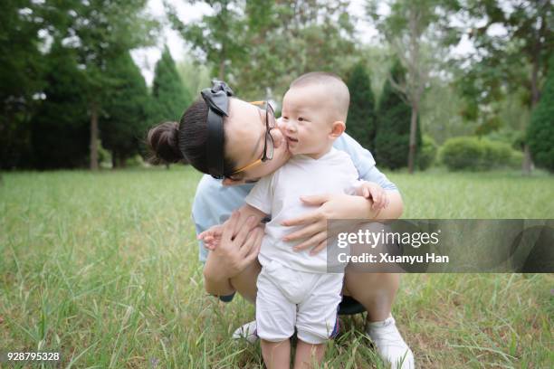 first steps: mother and her baby in the park - portrait of young woman standing against steps imagens e fotografias de stock