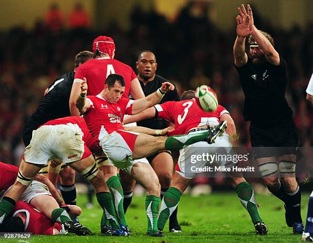 Gareth Cooper of Wales kicks ahead as Jason Eaton attempts a chargedown during the Invesco Perpetual Series match between Wales and New Zealand at...