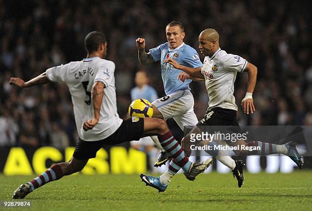 Craig Bellamy of Manchester City is challenged by Clarke Carlisle and Tyrone Mears of Burnley during the Barclays Premier League match between...
