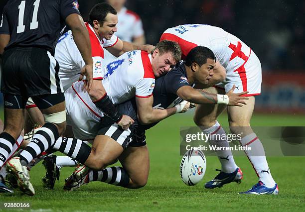 Junior Sau of New Zealand fumbles the ball as he is tackled during the Gillette Four Nations match between England and New Zealand at Galpharm...
