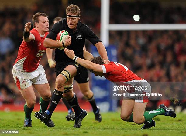 Brad Thorn of New Zealand breaks past Matthew Rees and Martin Roberts of Wales during the Invesco Perpetual Series Match between Wales and New...