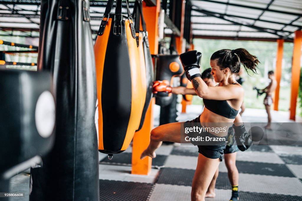 Woman kicking the punching bag