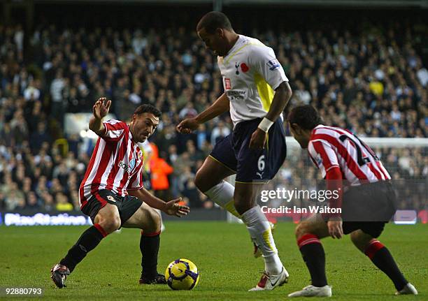 Tom Huddlestone of Tottenham Hotspur is closed down by Steed Malbranque and Andy Reid of Sunderland during the Barclays Premier League match between...