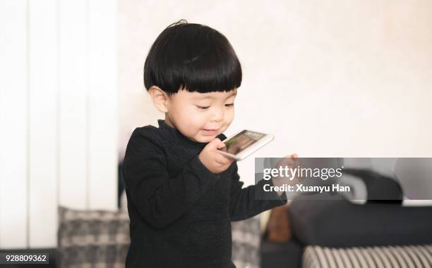 toddler playing with smartphone - one baby girl only stock pictures, royalty-free photos & images