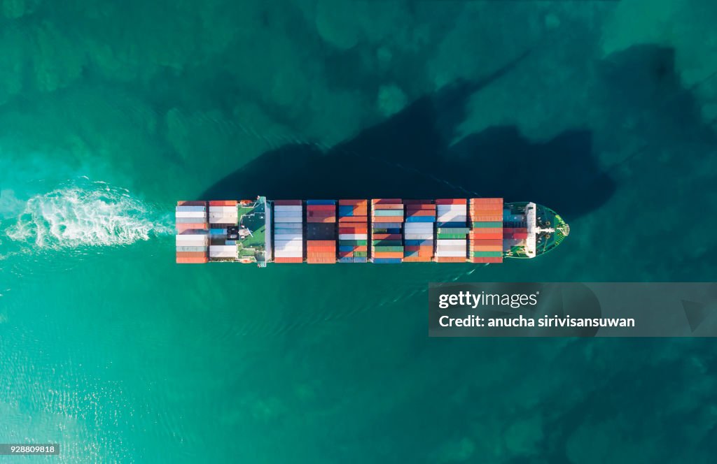 Aerial top view container ship running shipping container in sea.