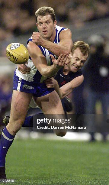 Glenn Archer for the Kangaroo's, is tackled by Adrian Hickmott for Carlton, during the round 9 AFL match between the Kangaroos and Calton, which was...