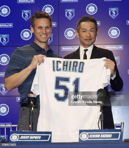Ichiro Suzuki holds his No. 51 jersey with Seattle Mariners general manager Jerry Dipoto during a press conference in Peoria, Arizona, on March 7 as...