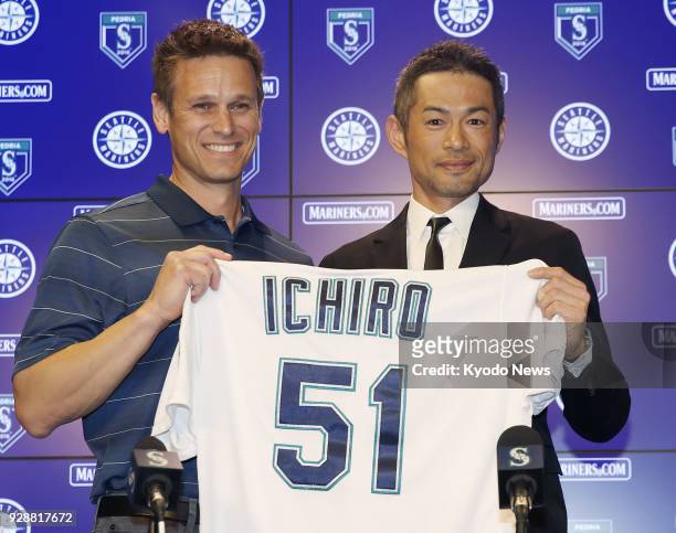 Ichiro Suzuki holds his No. 51 jersey with Seattle Mariners general manager Jerry Dipoto during a press conference in Peoria, Arizona, on March 7 as...