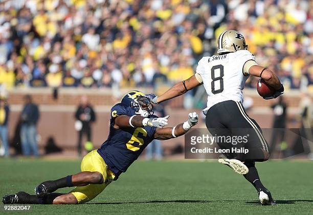 Kevin Smith of the Purdue Boilermakers runs for a first down against Donovan Warren of the Michigan Wolverines in the first quarter at Michigan...