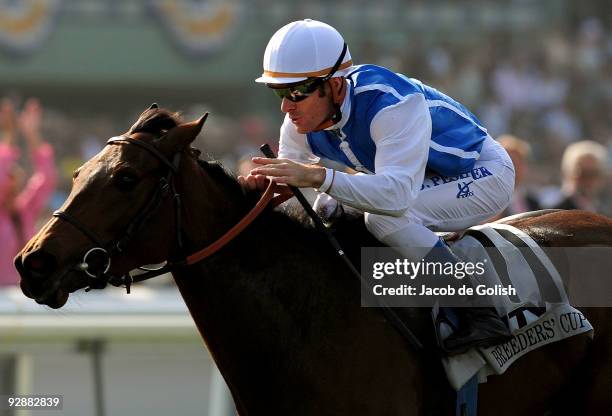 Jockey Olivier Peslier celebrates as he crosses the finish line to win the TVG Breeders' Cup Mile race with Goldikova during the Breeders' Cup World...