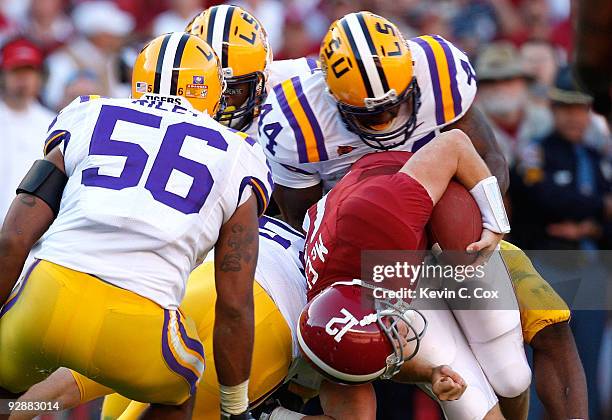 Perry Riley and Danny McCray of the Louisiana State University Tigers tackle quarterback Greg McElroy of the Alabama Crimson Tide at Bryant-Denny...