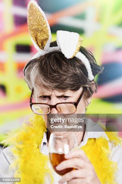 パーティーで、ウサギの耳とボアを着て古い女性を非難 - カチューシャ ストックフォトと画像