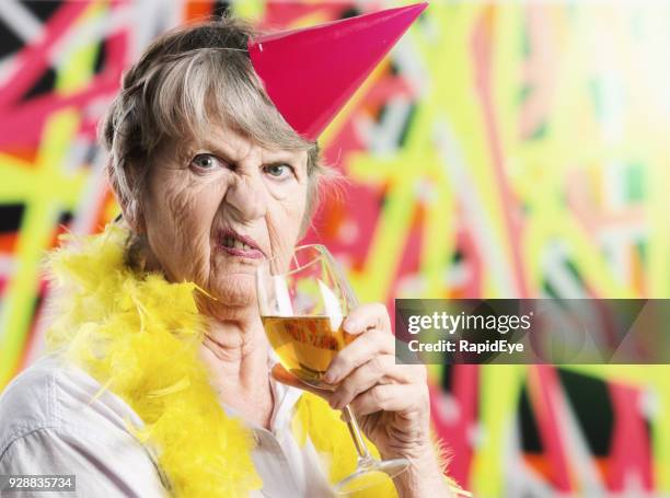 disgusted old woman in party hat does not approve - sour taste stock pictures, royalty-free photos & images