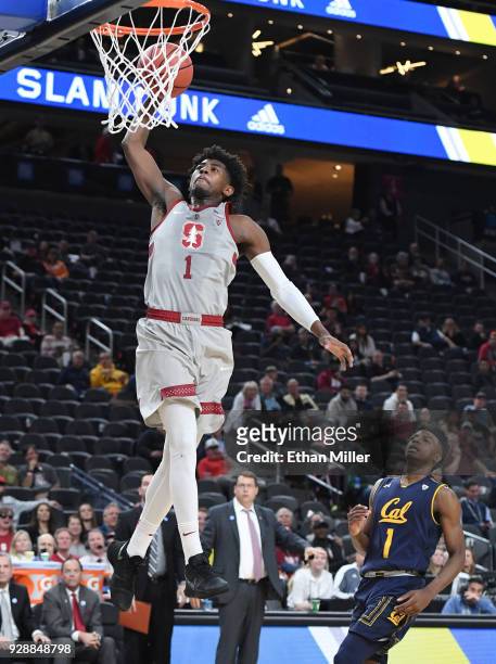Daejon Davis of the Stanford Cardinal dunks ahead of Darius McNeill of the California Golden Bears during a first-round game of the Pac-12 basketball...