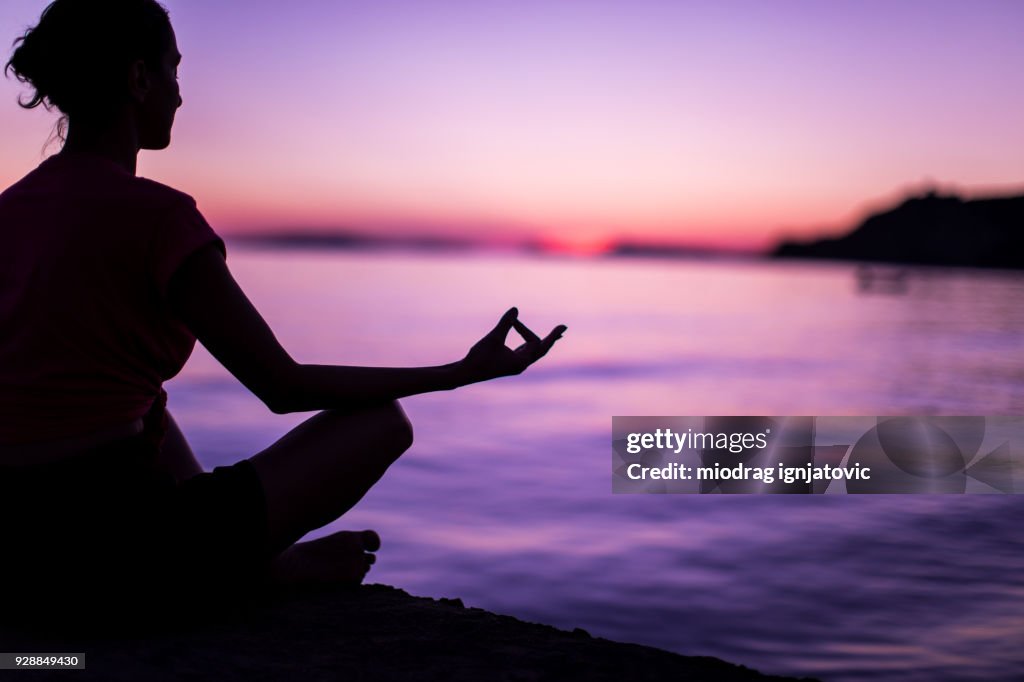 若い女性の穏やかな海で、瞑想