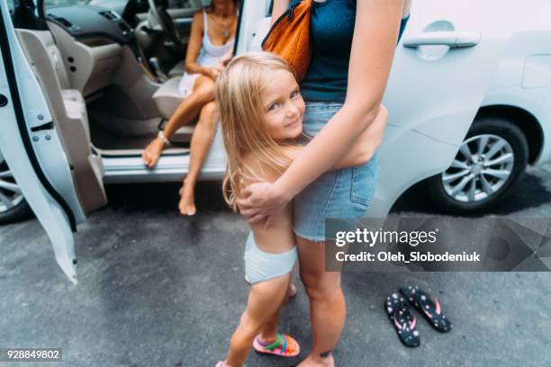 little girl embracing woman near the car - panties girl stock pictures, royalty-free photos & images