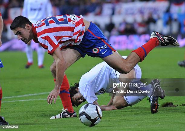 Pablo Ibanez of Atletico Madrid steps over Raul Gonzalez of Real Madrid during the La Liga match between Atletico Madrid and Real Madrid at the...