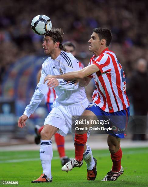 Pablo Ibanez of Atletico Madrid challenges Sergio Ramos of Real Madrid during the La Liga match between Atletico Madrid and Real Madrid at the...