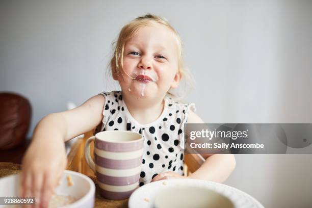 child enjoying eating breakfast - toddler mess stock-fotos und bilder