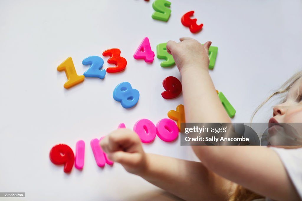 Toddler playing with magnetic letters and numbers