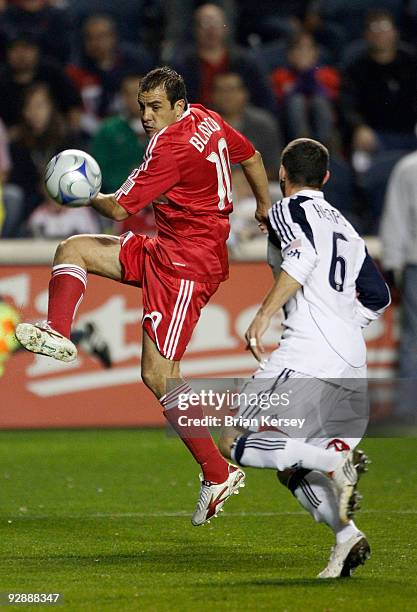 Cuauhtemoc Blanco of the Chicago Fire kicks the ball past Jay Heaps of the New England Revolution during the first half of Game Two of the Eastern...