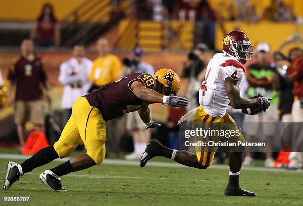 Runningback Joe McKnight of the USC Trojans rushes the ball past Brandon Magee of the Arizona State Sun Devils during the college football game at...