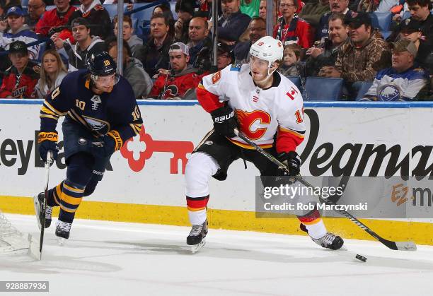 Matthew Tkachuk of the Calgary Flames looks to pass against Jacob Josefson of the Buffalo Sabres during an NHL game on March 7, 2018 at KeyBank...
