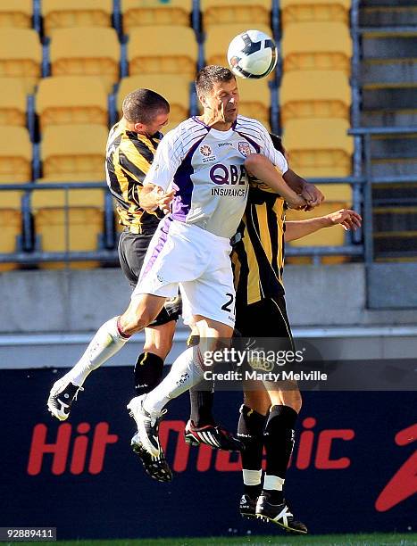 Mile Sterjovski of the Glory jumps for the ball with Andrew Durante captain and Manny Muscat of the Phoenix during the round 14 A-League match...