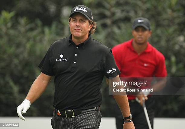 Phil Mickelson of the USA watches the tee shot of Tiger Woods on the fourth hole during the final round of the WGC - HSBC Champions at Sheshan...