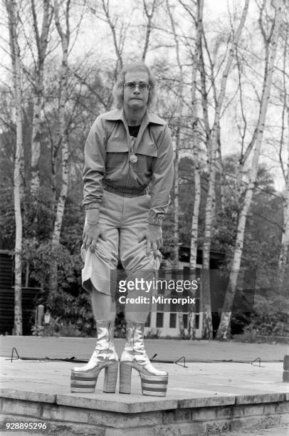 Elton John, singer, pictured at home in Virginia Water, in 1973. He is playing for the camera, over 3 pictures, pulling faces and showing off his...