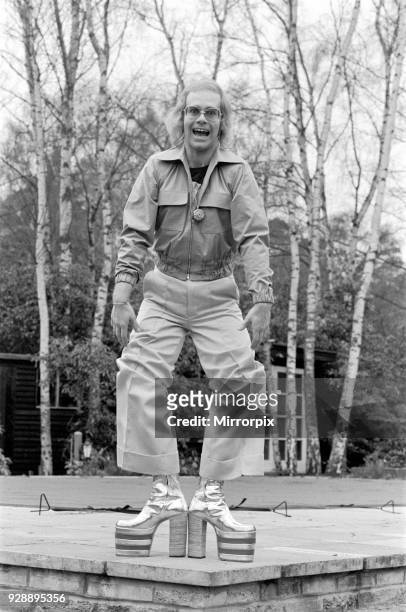 Elton John, singer, pictured at home in Virginia Water, in 1973. He is playing for the camera, over 3 pictures, pulling faces and showing off his...