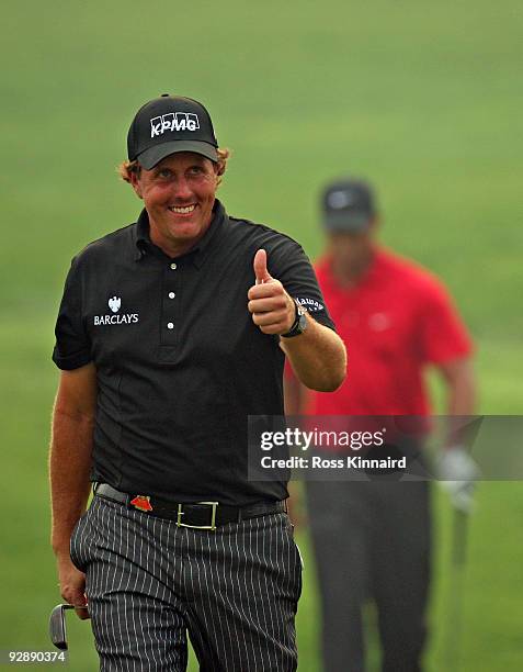 Phil Mickelson of the USA is followed on to the 18th green by Tiger Woods of the USA during the final round of the WGC - HSBC Champions at Sheshan...