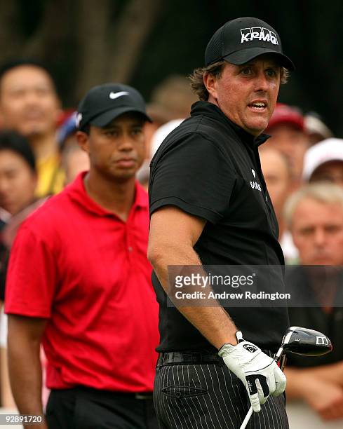 Phil Mickelson of the USA watches his tee-shot on the 13th hole as Tiger Woods of the USA looks on during the final round of the WGC-HSBC Champions...