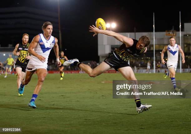 Dylan Grimes of the Tigers and Mason Wood of the Kangaroos compete for the ball during the AFL 2018 JLT Community Series match between the Richmond...