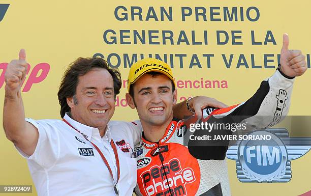 Spanish rider Hector Barbera celebrates on the podium with Sito Pons after winning the 250cc race of the Valencia motorcycling Grand Prix at the...