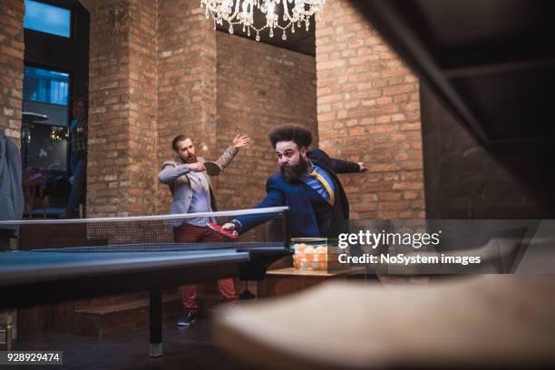 group of young start up businessman playing table tennis at modern creative space - table tennis stock pictures, royalty-free photos & images