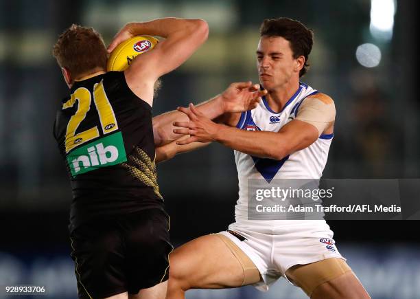 Jacob Townsend of the Tigers is tackled by Luke Davies-Uniacke of the Kangaroos during the AFL 2018 JLT Community Series match between the Richmond...