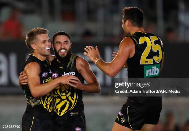 Dan Butler of the Tigers celebrates a goal with Shane Edwards and Toby Nankervis of the Tigers during the AFL 2018 JLT Community Series match between...