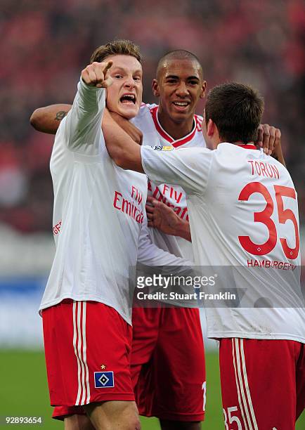 Marcell Jansen of Hamburg celebrates scoring his team's first goal with team mates Tunay Torun and Jerome Boateng during the Bundesliga match between...