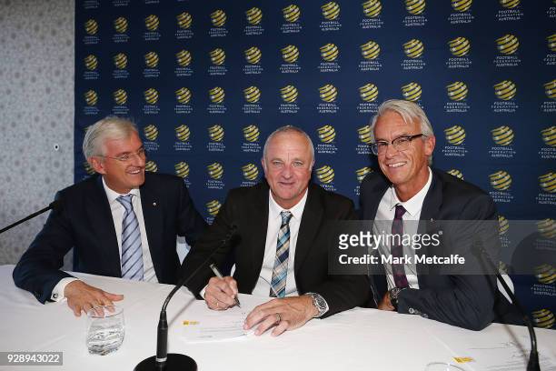 Graham Arnold signs a contract alongside FFA Chairman Steven Lowy and FFA CEO David Gallop during a press conference announcing the succession plan...