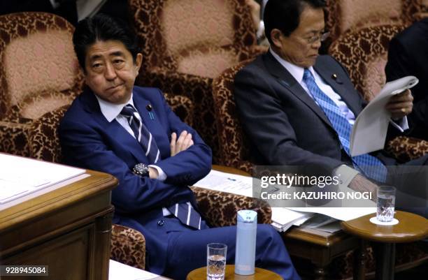 Japan's Prime Minister Shinzo Abe and Finance Minister Taro Aso attend an upper house budget committee session of parliament in Tokyo on March 8,...