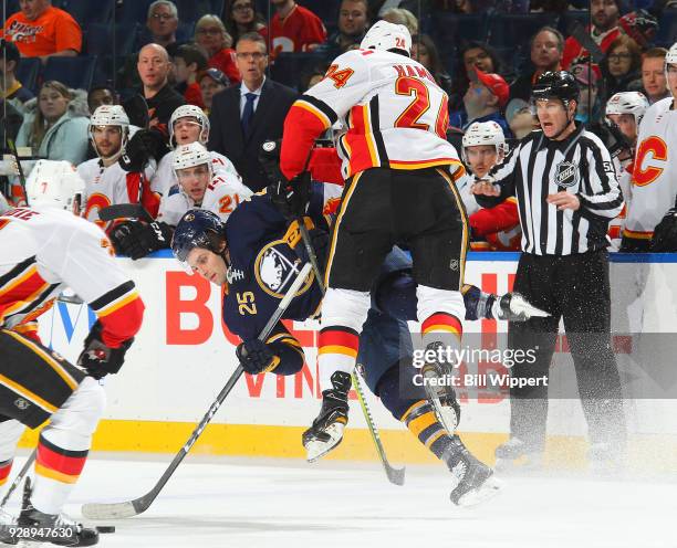 Travis Hamonic of the Calgary Flames checks Seth Griffith of the Buffalo Sabres during the third period of an NHL game on March 7, 2018 at KeyBank...