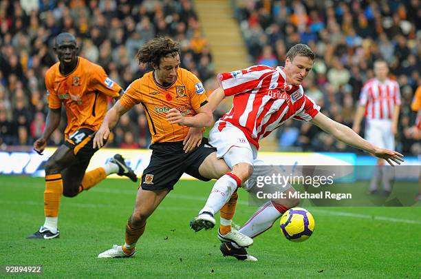 Robert Huth of Stoke City is challenged by Stephen Hunt of Hull City during the Barclays Premier League match between Hull City and Stoke City at the...