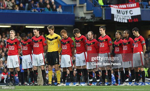 The Manchester United team take part in a minute's silence on Remembrance Sunday during the Barclays Premier League match between Chelsea and...