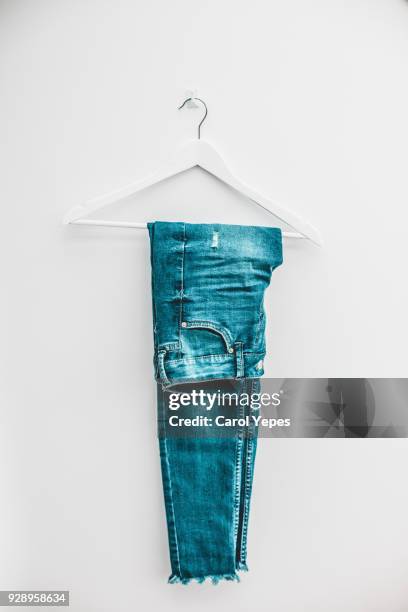 denim jeans on hanger - coat hanger stock-fotos und bilder