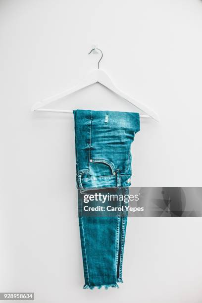 denim jeans on hanger - coathanger photos et images de collection