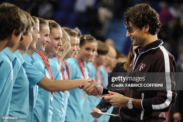 Switzerland's Roger Federer shakes hands with a ball girl during the ceremony after he lost against Serbia's Novak Djokovic during the finals at the...